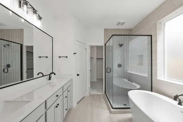a bathroom with a double vanity sink a toilet a mirror and shower