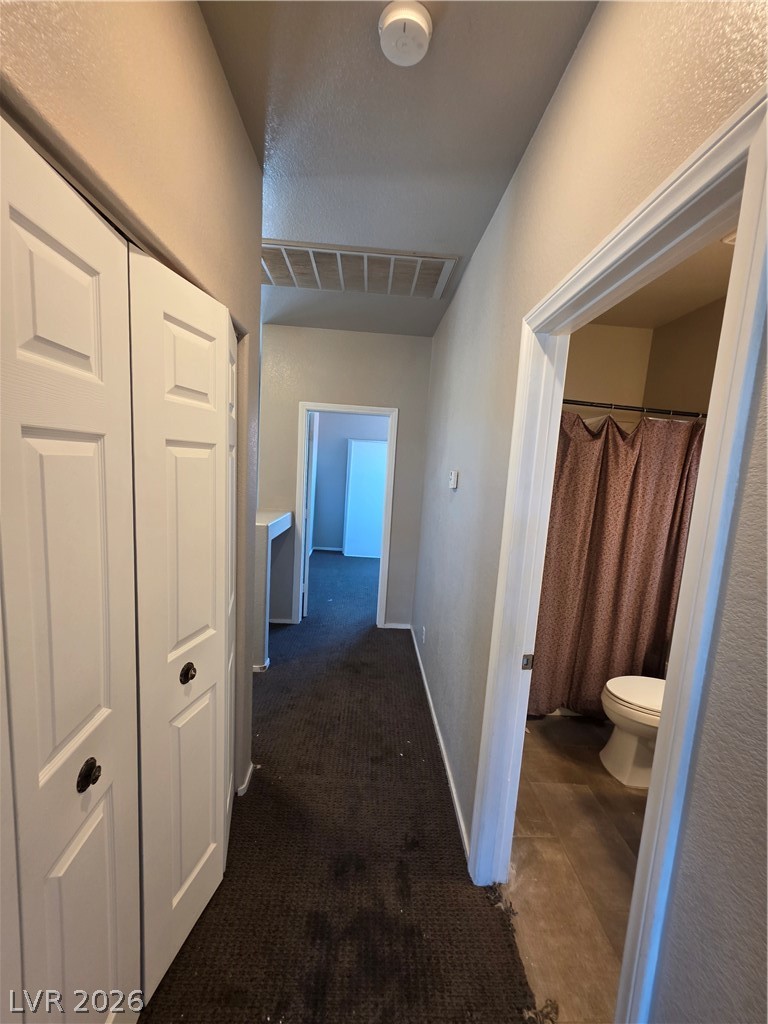 2275 Ramsgate Drive Henderson, NV 89074 - Photo 66 of 84 Hallway leading to bathroom and other rooms, featuring panel doors and carpeted flooring.