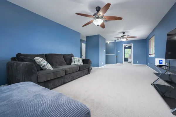 a living room with furniture a chandelier and a flat screen tv