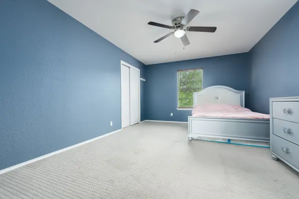 a bedroom with a bed and a ceiling fan
