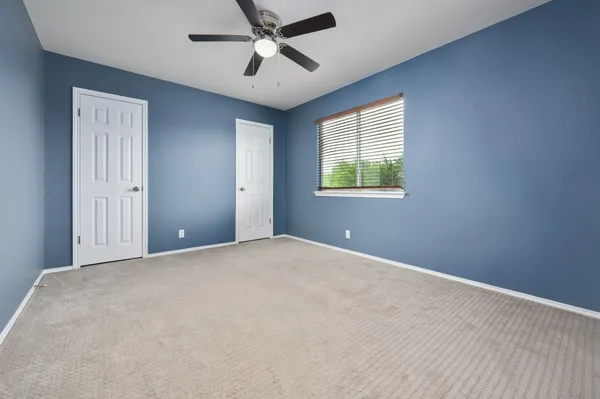 a view of a big room with windows and chandelier fan