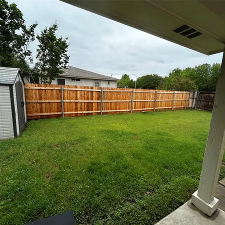 a view of a yard with wooden fence