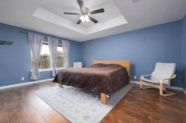 a spacious bedroom with a bed and chair