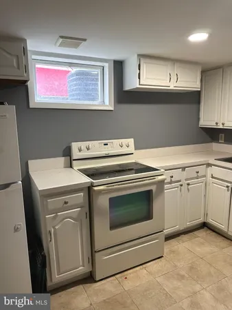 a kitchen with granite countertop a sink cabinets and wooden floor