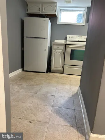 a kitchen with a stove top oven and a refrigerator