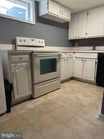 a kitchen with a stove top oven and cabinets
