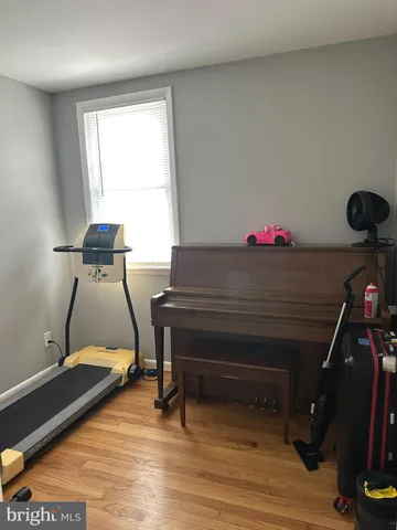 a room with gym equipment and wooden floor
