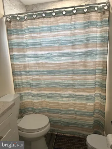 a bathroom with a toilet and a shower curtain