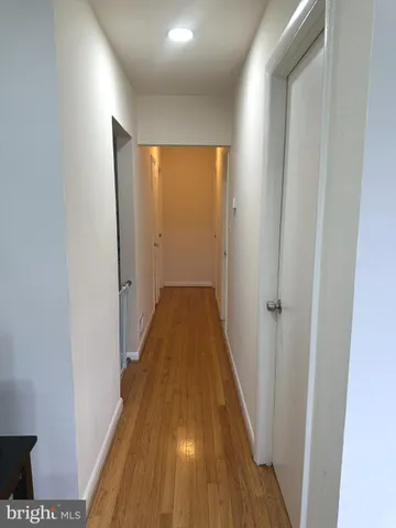 a view of a hallway with wooden floor