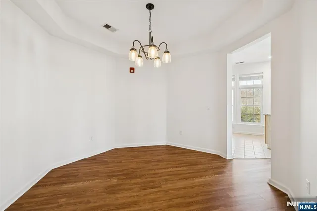 a view of a big room with wooden floor and windows