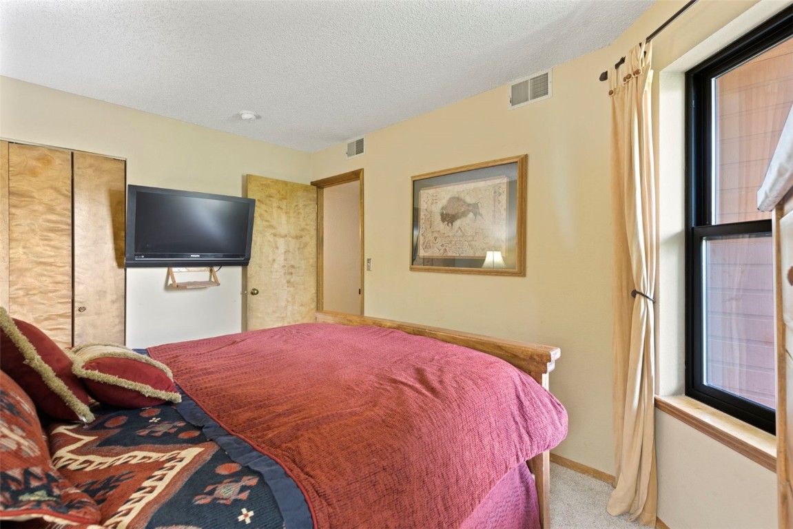 570 Bills Ranch Road, Unit 325 Frisco, CO 80443 - Photo 14 of 30 a bedroom with a bed and a flat screen tv