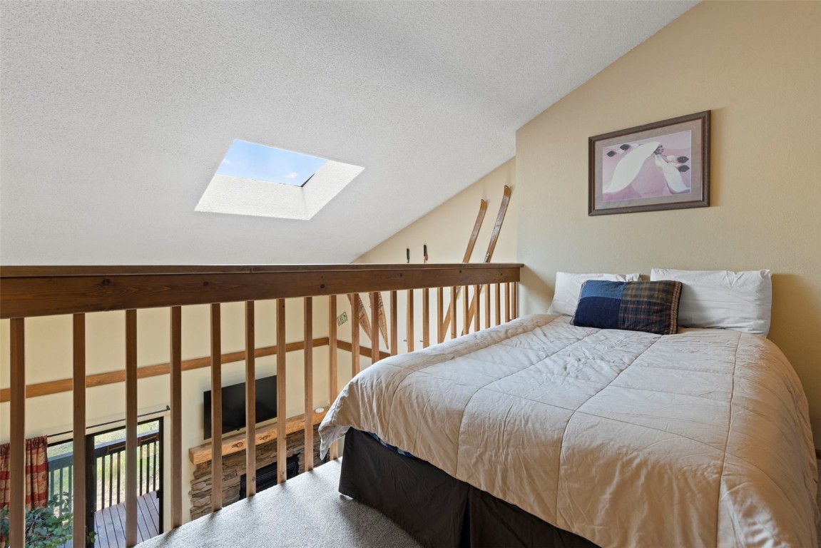 570 Bills Ranch Road, Unit 325 Frisco, CO 80443 - Photo 15 of 30 a bed sitting in a bedroom next to a wooden floor