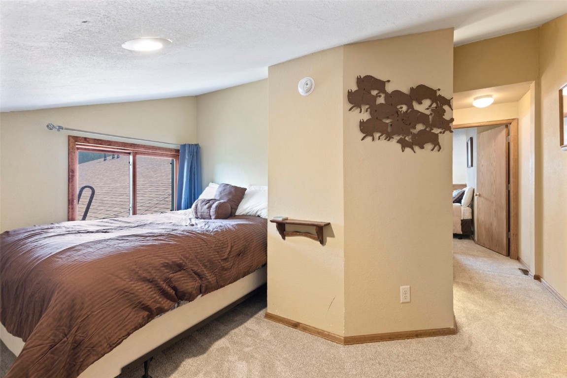 570 Bills Ranch Road, Unit 325 Frisco, CO 80443 - Photo 21 of 30 a bedroom with a bed and a chandelier