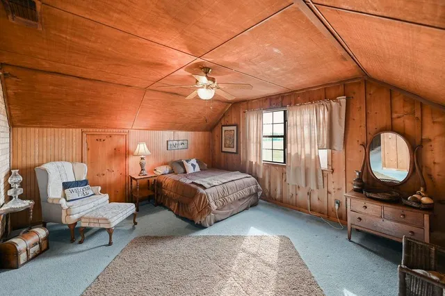 a bedroom with a bed mirror and window