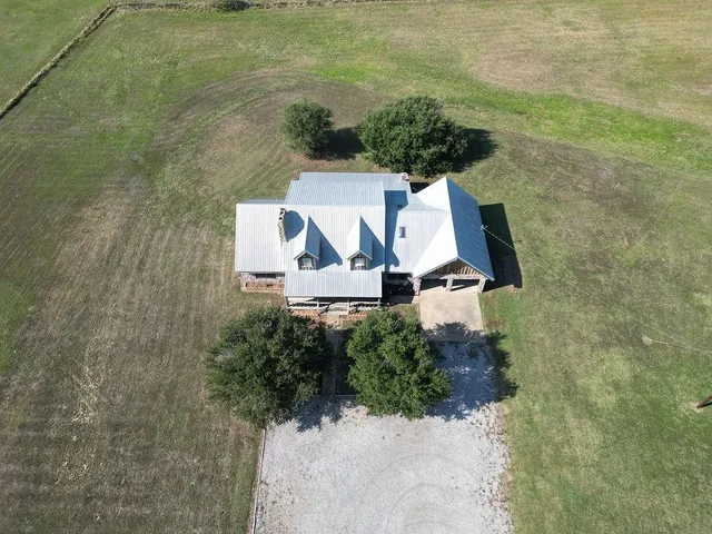 an aerial view of a house with a yard and outdoor seating