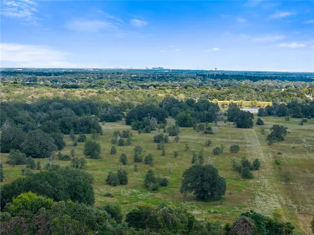 a view of dirt field with trees in the background