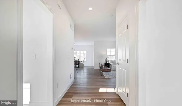 a view of a hallway with wooden floor and a living room