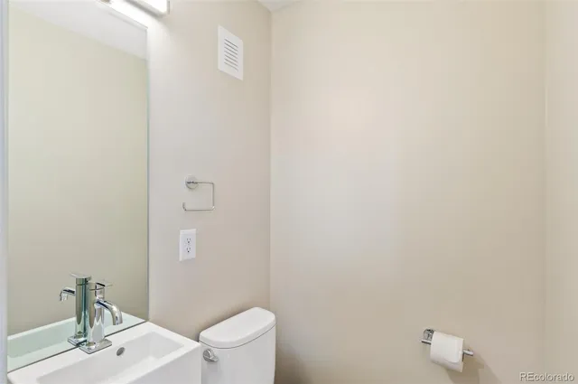 a bathroom with a sink a toilet a mirror and shower