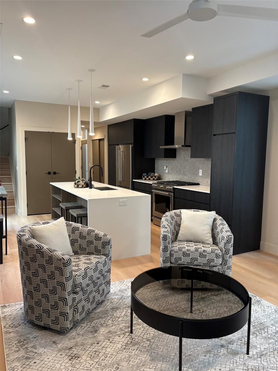 2323 South High Street Denver, CO 80210 - Photo 3 of 21 a living room with furniture a flat screen tv and kitchen view