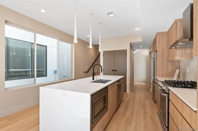 a kitchen with sink stove and refrigerator