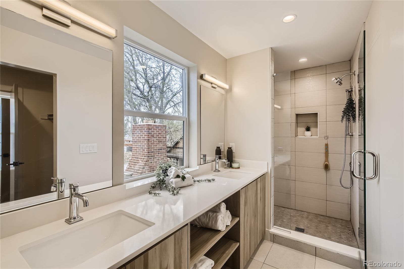 2323 South High Street Denver, CO 80210 - Photo 8 of 21 a bathroom with double vanity sinks and a mirror