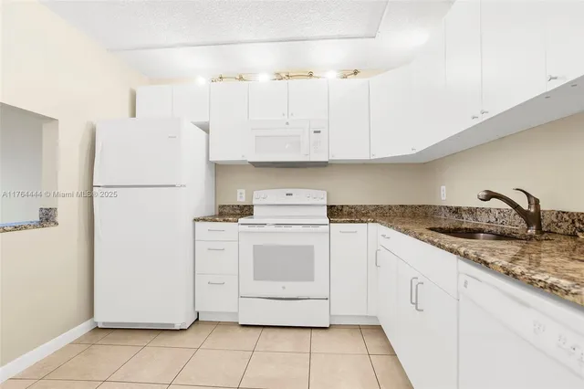 a utility room with cabinets washer and dryer