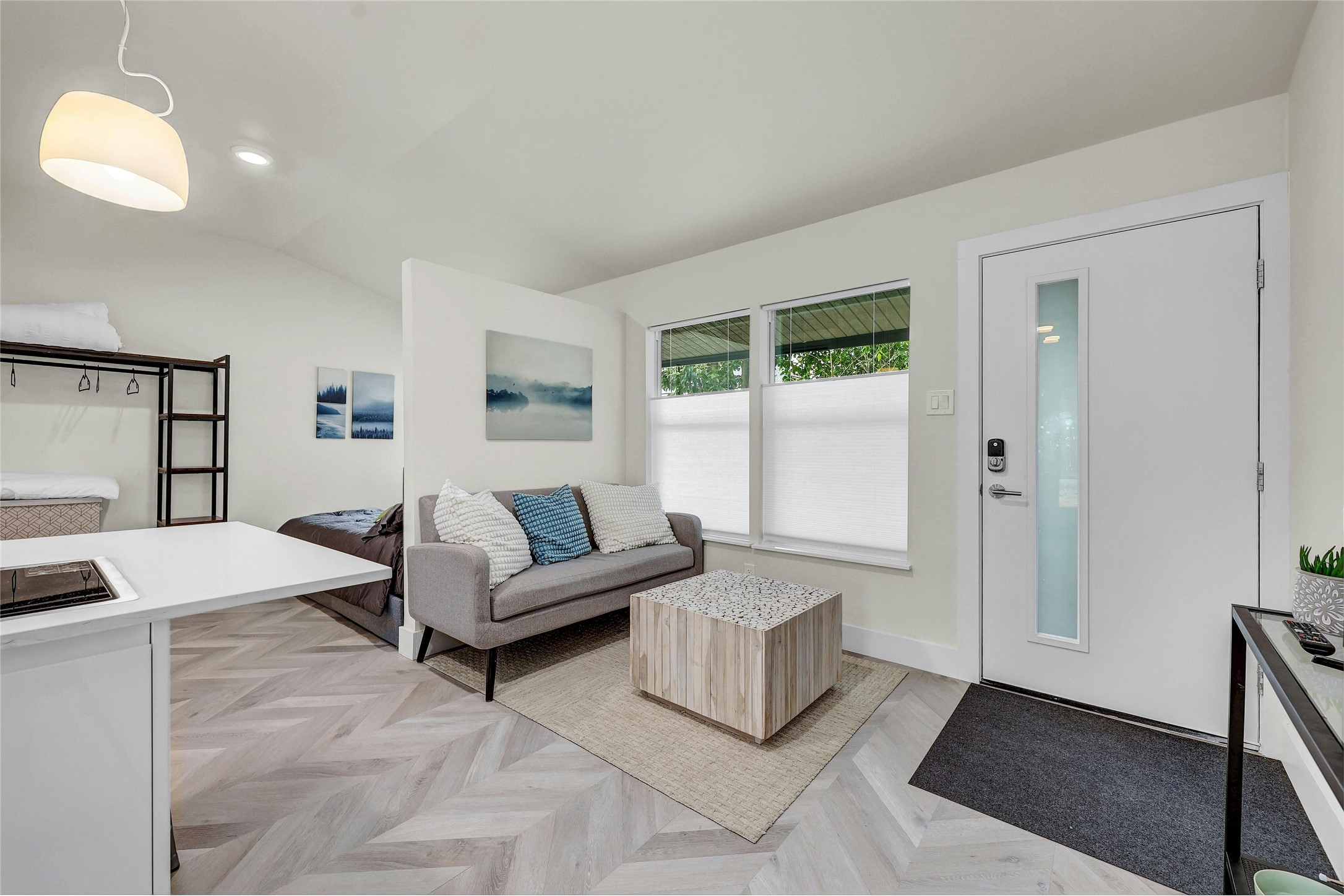 2201 Leon Street Austin, TX 78705 - Photo 14 of 30 Herringbone pattern wood flooring unites a modern living area with an open kitchen and sleeping alcove.