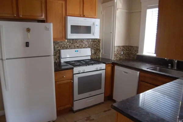 a kitchen with a stove cabinets and a refrigerator