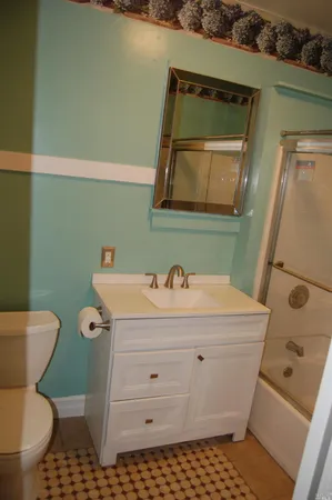 a bathroom with a sink a toilet and mirror