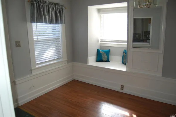 a small space with wooden floor and a window
