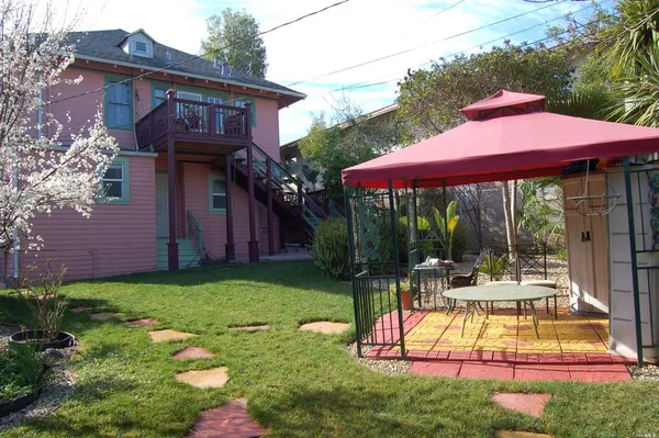 a view of a house with backyard sitting area and garden