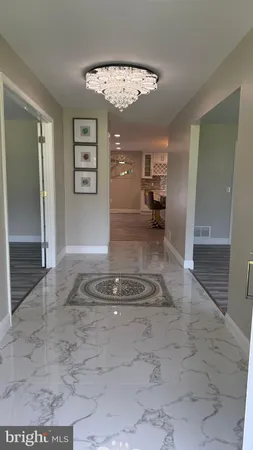 a kitchen with stainless steel appliances granite countertop a stove top oven a sink dishwasher and a chairs with wooden floor