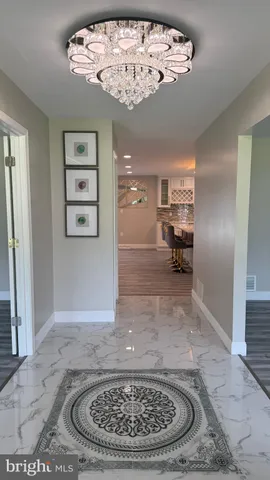 a living room with furniture wooden floor and kitchen view