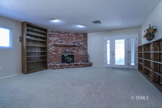 516 Randall Street Ridgecrest, CA 93555 - Photo 18 of 50 a view of an empty room with a fireplace and window