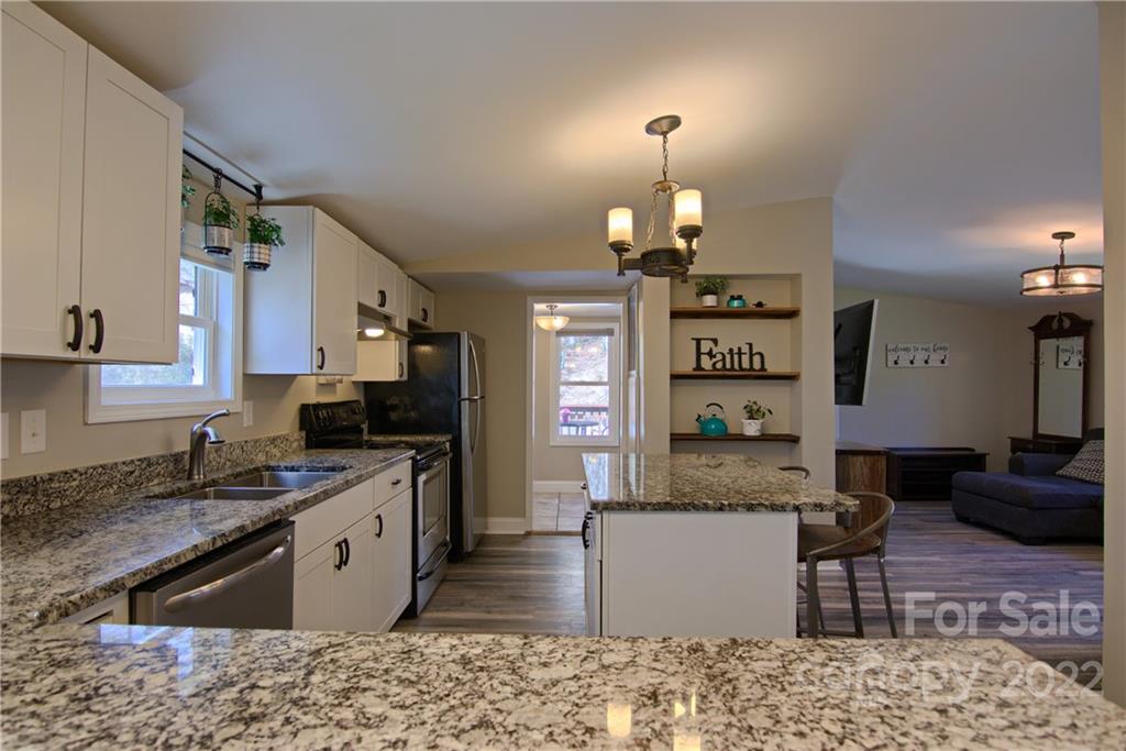 20 Cascade Village Road, Unit 2 Pisgah Forest, NC 28768 - Photo 11 of 36 a kitchen with stainless steel appliances granite countertop a sink stove and refrigerator
