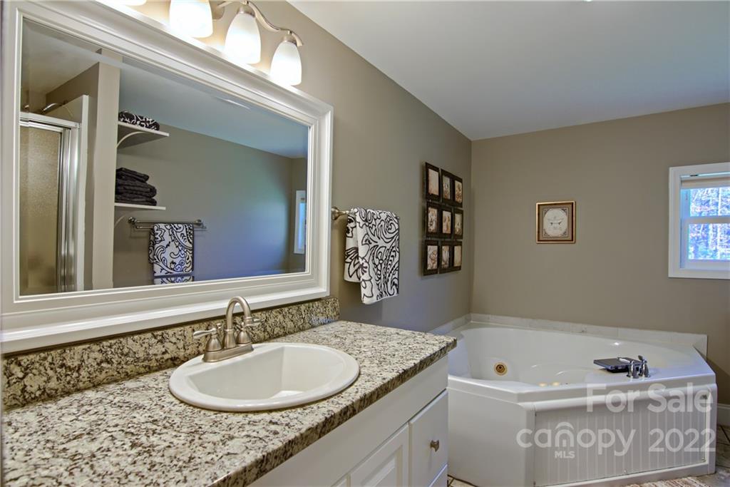 20 Cascade Village Road, Unit 2 Pisgah Forest, NC 28768 - Photo 19 of 36 a bathroom with a granite countertop sink and a mirror