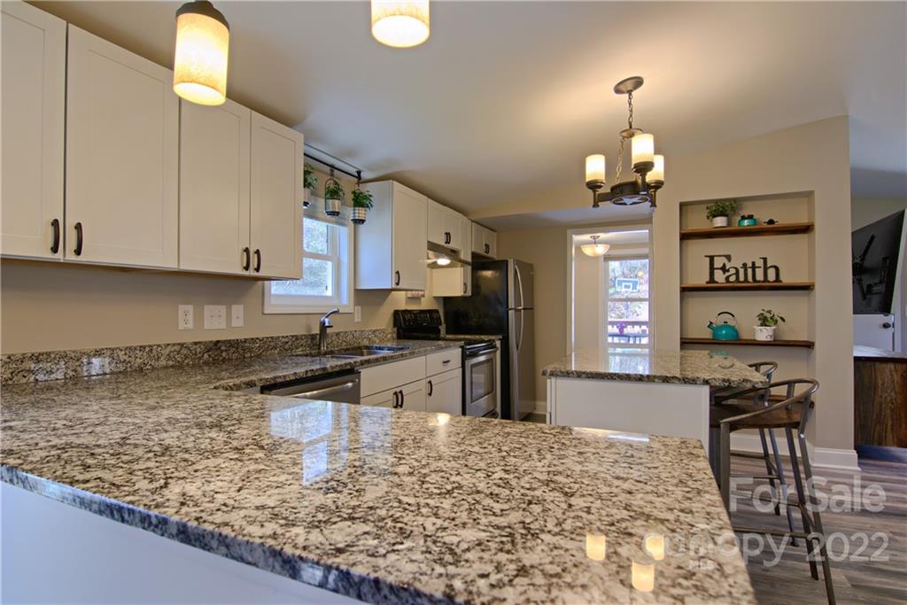 20 Cascade Village Road, Unit 2 Pisgah Forest, NC 28768 - Photo 6 of 36 a kitchen with stainless steel appliances granite countertop a sink stove and refrigerator