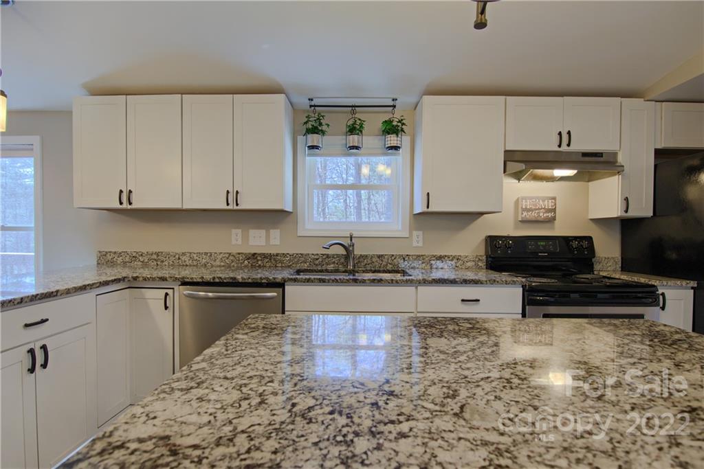 20 Cascade Village Road, Unit 2 Pisgah Forest, NC 28768 - Photo 8 of 36 a kitchen with stainless steel appliances granite countertop a stove a sink and a white cabinets