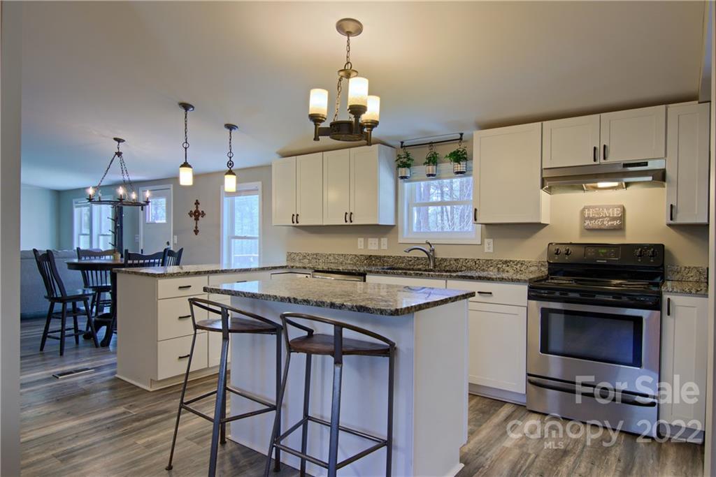 20 Cascade Village Road, Unit 2 Pisgah Forest, NC 28768 - Photo 9 of 36 a kitchen with a stove a sink and a refrigerator