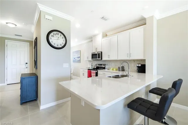 a open kitchen with stainless steel appliances kitchen island a sink dishwasher a stove with white cabinets and couches