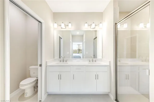 a bathroom with a double vanity sink mirror and shower