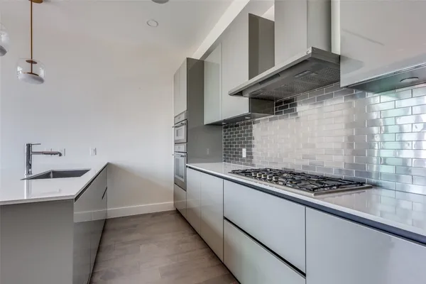 a kitchen with granite countertop a sink stove and cabinets