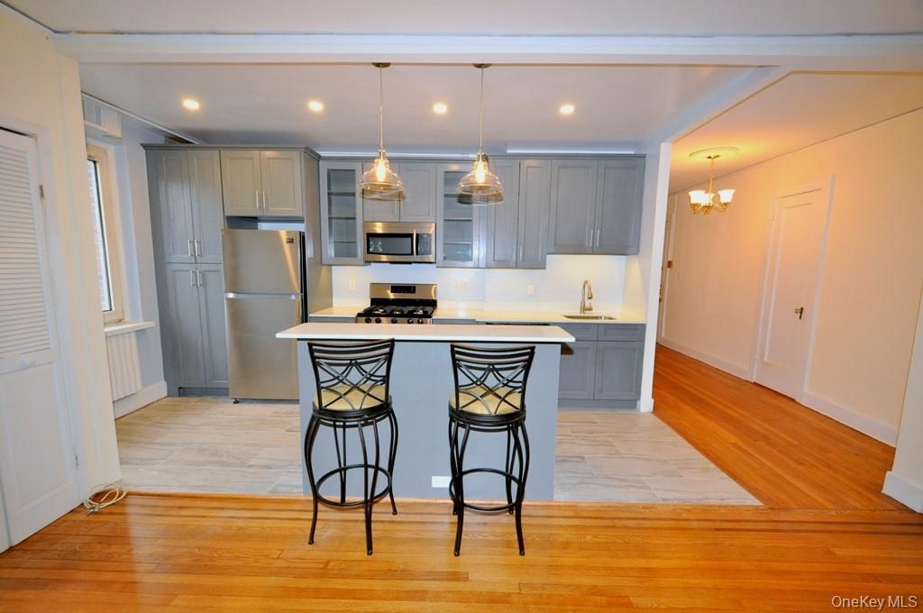 69 Harney Road, Unit 3A Scarsdale, NY 10583 - Photo 2 of 22 Renovated Kitchen with center Island, pendent lighting, Granite Counters, Stainless Steel Appliance including a dishwasher, range, microwave and refrigerator. The wall separating the eat-in-kitchen and living room have been removed and a center Island installed with electric and USB outlets installed to create an open concept.