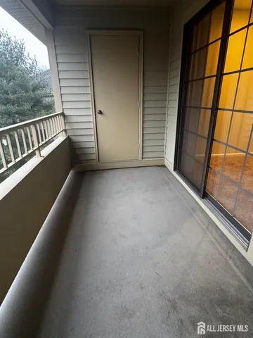 a view of an empty room with a window and a kitchen