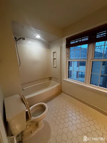 an empty room with windows and ceiling fan