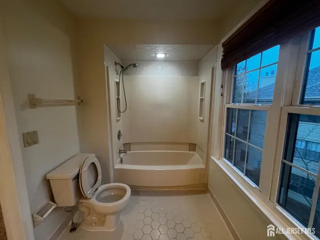a bathroom with a granite countertop toilet a sink and a bathtub