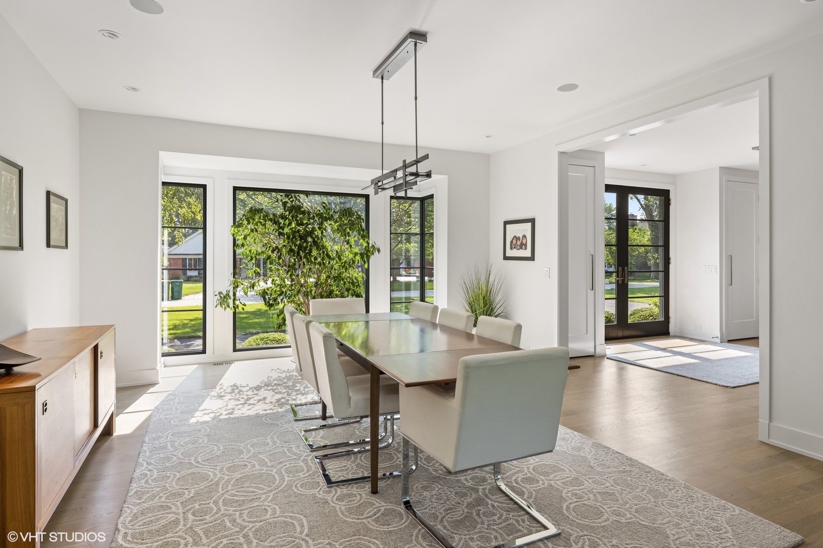 15 Longmeadow Road Winnetka, IL 60093 - Photo 14 of 71 a dining room with wooden floor a chandelier a glass table and windows