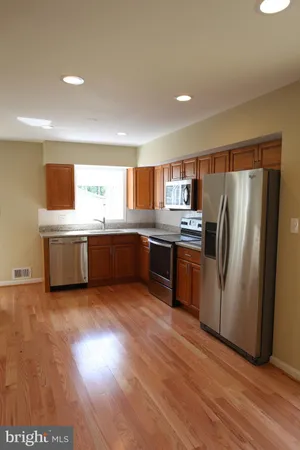 a kitchen with stainless steel appliances a refrigerator and a stove top oven