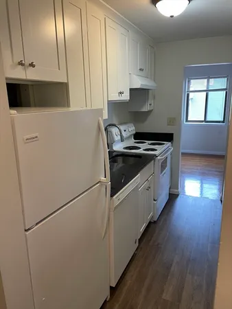 a kitchen with a refrigerator sink and cabinets