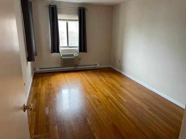 a view of a room with wooden floor and a window